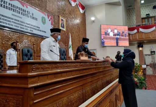 Hj Kamsiah Rahman dari Fraksi Nasdem menyerahkan laporan pandangan fraksi ke Ketua DPRD Kutim, Joni. (Ramlah/Kaltimtoday.co).