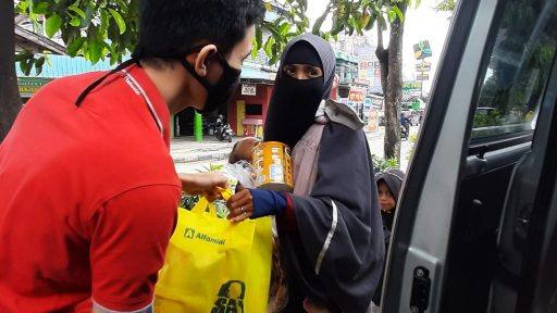 Warga menerima kado Ramadhan donasi dari konsumen Alfamidi.