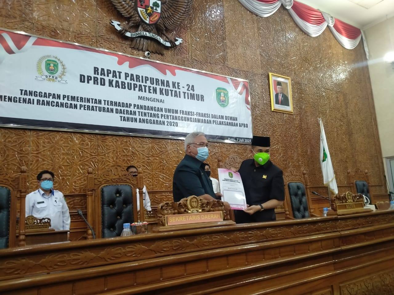 Sekretaris Kabupaten Kutai Timur, Irawansyah saat menyerahkan laporan pemandangan umum fraksi ke Ketua DPRD Kutim Joni. (Ramlah/Kaltimtoday.co).