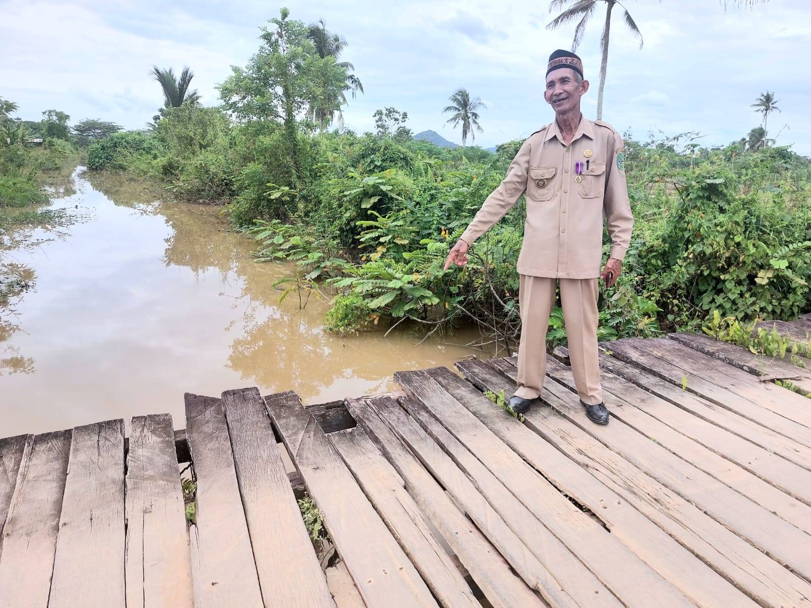 Kades Ponoragan, Sarmin saat menunjukkan salah satu kerusakan jembatan penghubung antar desa. (Supri/Kaltimtoday.co)